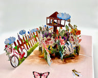 Lush garden pop up card with a bicycle and flowers.