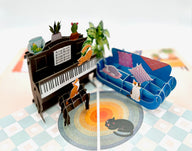An interactive pop-up card with cats playing on a piano and sofa, a unique birthday card idea.